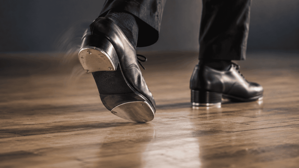 Close-up of metal toe and heel taps on dance shoes striking a wooden floor